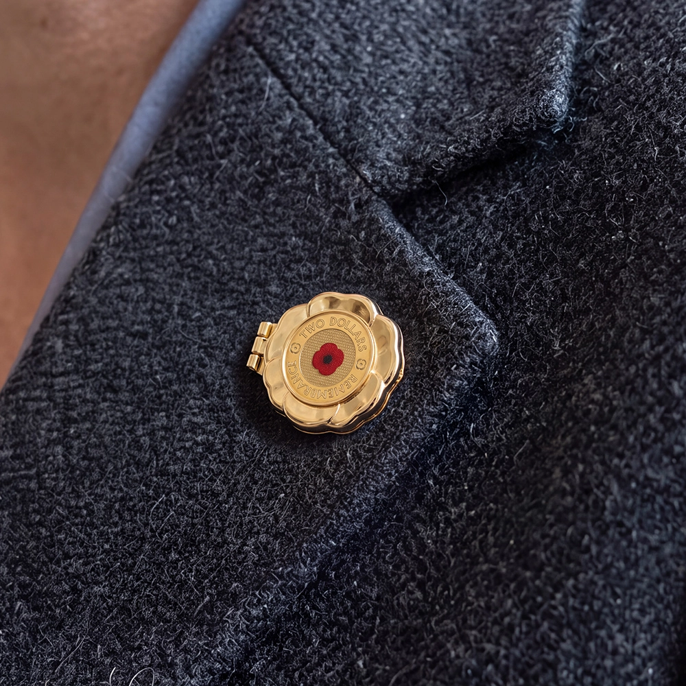 A close up of the Forever Remembrance Coin Locket Brooch pinned to a coat with an Australian $2 coin inside
